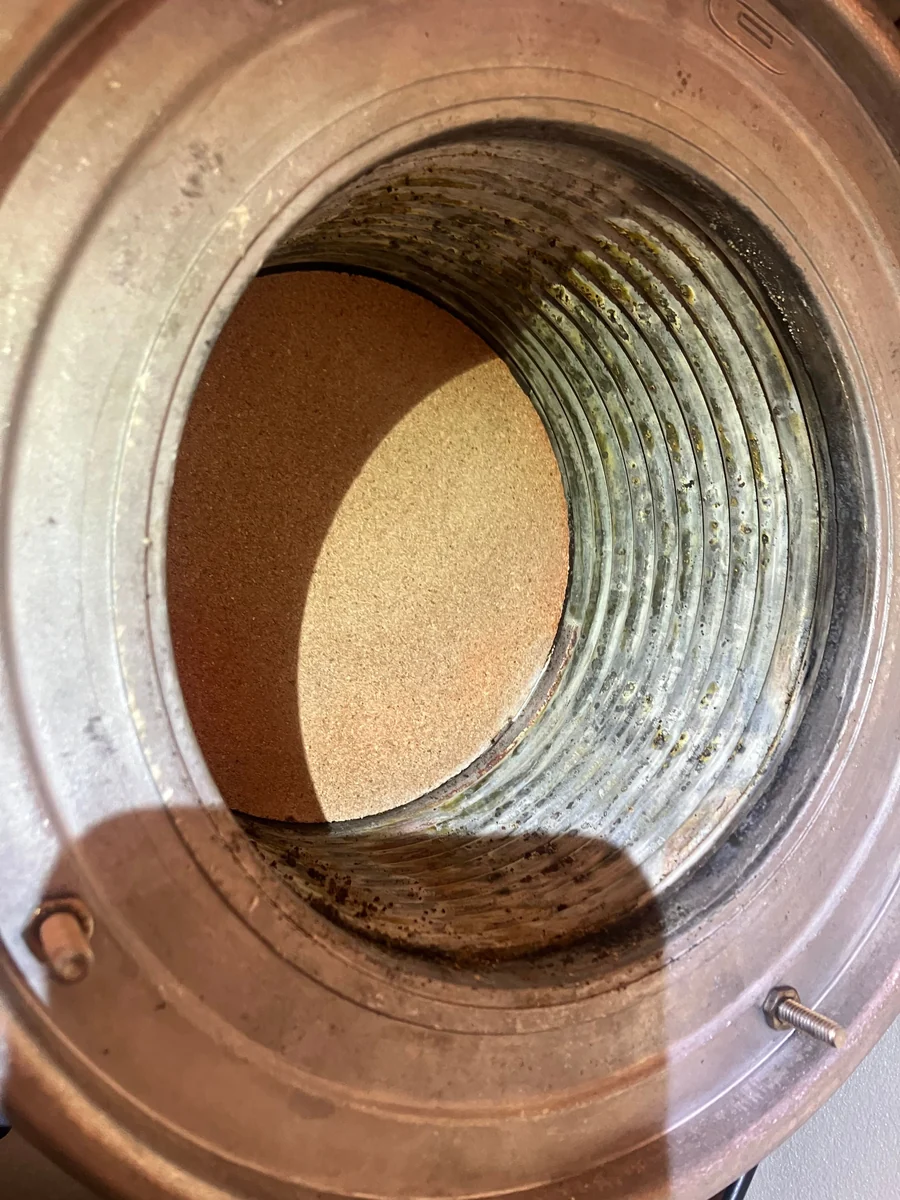 Heat exchanger bore opened up during a boiler service, showing combustion deposits before cleaning
