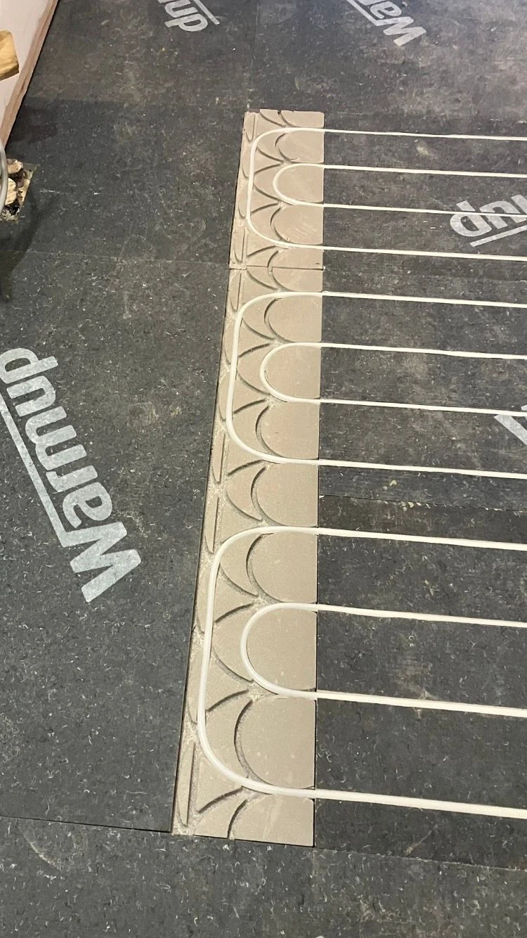 Electric underfloor heating cable laid in loops over insulation board